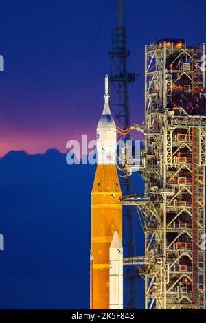 La fusée SLS (Space Launch System) de la NASA, à bord de l'engin spatial Orion, est vue au sommet du lanceur mobile du Launch 39B au Kennedy Space Center de la NASA, en Floride. La mission Artemis I est le premier test intégré des systèmes d’exploration spatiale profonde de l’agence : la fusée Space Launch System, l’engin spatial Orion et les systèmes de soutien au sol. La mission est la première d'une série de missions de plus en plus complexes sur la Lune. Le lancement de l'essai en vol sans équipage est prévu au plus tôt le 3 septembre à 2 h 17 HE. Avec les missions Artemis, la NASA atterrira la première femme et la première personne de couleur sur le Banque D'Images