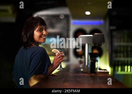 Messagerie instantanée en attente de quelqu'un. Une jolie jeune fille assise au bar seule en attente de compagnie. Banque D'Images