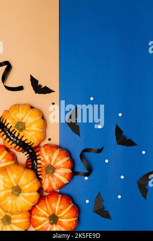 Halloween Symbol concept, Centipede sur des citrouilles à sourire effrayant avec des chauves-souris sur fond bleu et crème. Banque D'Images