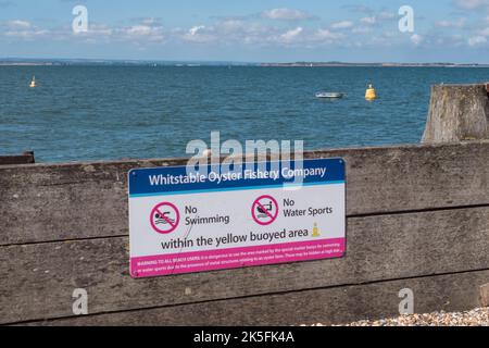 Panneau « Whitstable Oyster Fishery Company » avertissant les gens au sujet de la natation et des sports nautiques sont interdits à proximité des lits d'huîtres, Whitstable, Kent, Royaume-Uni. Banque D'Images