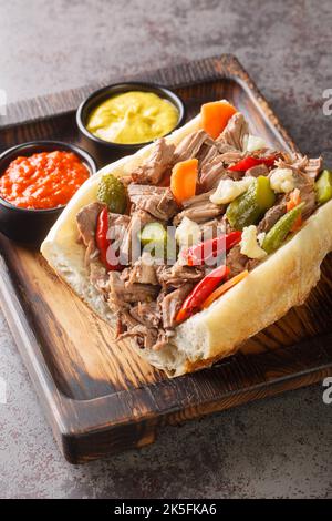 Sandwich au bœuf italien de style Chicago sur le plateau en bois de la table. Verticale Banque D'Images