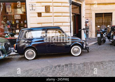 Fiat 500 bleu foncé classique garé sur une rue pavée à Rome Banque D'Images