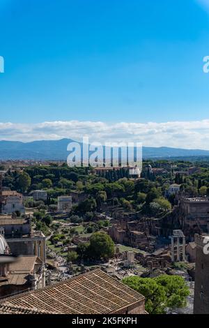 Vue panoramique sur les ruines antiques du Forum romain avec des montagnes lointaines et un ciel bleu Banque D'Images