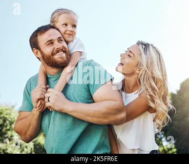 La famille, les enfants et la nature avec une fille, une mère et un père dans un parc pour le plaisir ou l'aventure ensemble. Enfants, heureux et amour avec un homme, une femme et Banque D'Images