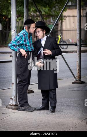 2 adolescents juifs s'engagent dans une conversation animée sur Lee avenue à Williamsburg, Brooklyn, New York. Banque D'Images