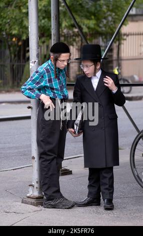 2 adolescents juifs s'engagent dans une conversation animée sur Lee avenue à Williamsburg, Brooklyn, New York. Banque D'Images