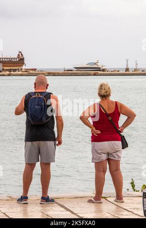 vieux couple à la retraite, vue sur la mer ensemble du côté du port sur l'île grecque de zakynthos en grèce., touristes anglais, côté eau. Banque D'Images
