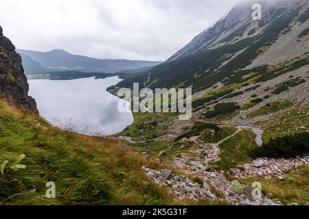 Montagne dans les Tatras polonais avec un petit lac turquoise et rochers au milieu de la montagne avec brouillard blanc et nuages Banque D'Images