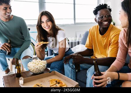 Joyeux amis divers s'amuser ensemble à manger de la pizza à la maison Banque D'Images