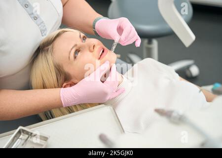 Dentiste tenant des aligneurs transparents près de la bouche du patient Banque D'Images