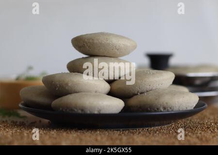 Millet Kodo sans rien. Gâteaux salés cuits à la vapeur, faits de millésimes de kodo et de farine de lentilles, servis avec un condiment épicé de noix de coco. Le millet de Kodo est utilisé comme mil sain Banque D'Images