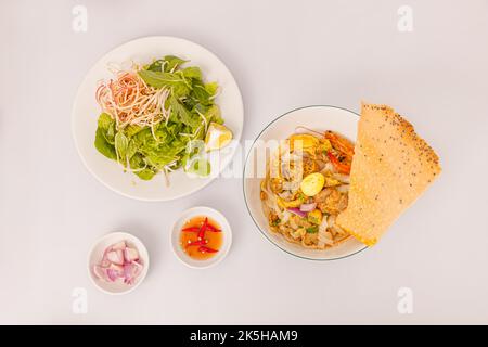 Mi Quang, nouilles de riz vietnamiennes avec viande, bouillon de poulet, crevettes, œuf, nourriture vietnamienne isolée sur fond blanc, vue de dessus Banque D'Images