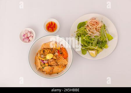 Mi Quang, nouilles de riz vietnamiennes avec viande, bouillon de poulet, crevettes, œuf, nourriture vietnamienne isolée sur fond blanc, vue de dessus Banque D'Images