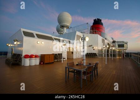 La vue sur le pont supérieur du bateau de croisière Queen Victoria, une croisière Cunard. Queen Victoria terrasse supérieure la nuit, coucher de soleil. Banque D'Images