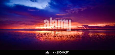 Scène panoramique du coucher du soleil sur la plage de Cheung Tha. Ciel nuageux. Heure de fin en bord de mer. Banque D'Images