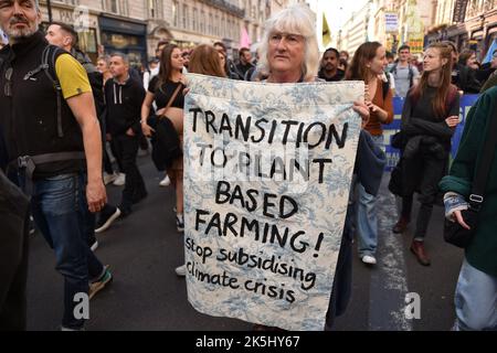 Londres, Angleterre, Royaume-Uni. 8th octobre 2022. La militante tient une bannière exprimant son opinion lors de la manifestation, à Piccadilly Street, Londres. La rébellion animale s'est jointe aux environnementalistes de Just Stop Oil, les végétaliens et les militants des droits des animaux sont descendus dans les rues du centre de Londres pour réclamer un avenir basé sur les usines. (Image de crédit : © Thomas Krych/ZUMA Press Wire) Banque D'Images