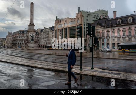 Lisbonne, Portugal - septembre 2022 : place Restauradores par temps pluvieux à Lisbonne, avec un flou de mouvement sélectif sur l'homme traversant la rue Banque D'Images