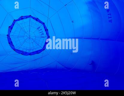 France, Essonne (91), Saclas, gonflage à l'air d'un ballon d'air chaud et contrôle de la valve supérieure et de l'enveloppe par son pilote Banque D'Images