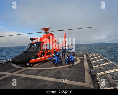 Garde côtière Cutter Garde côtière Cutter Steadfast (WMEC 623) les membres de l'équipage de pont de vol s'exercent à retirer les points d'arrimage primaires d'un hélicoptère MH-65 Dolphin de la station aérienne Humboldt Bay dans le cadre de leur processus de qualification, alors que Steadfast patrouilla dans l'océan Pacifique, le 16 août 2022. Steadfast est retourné à son Astoria homeport le 3 octobre 2022, après une patrouille de 55 jours contre les stupéfiants. Photo de la Garde côtière américaine. Banque D'Images