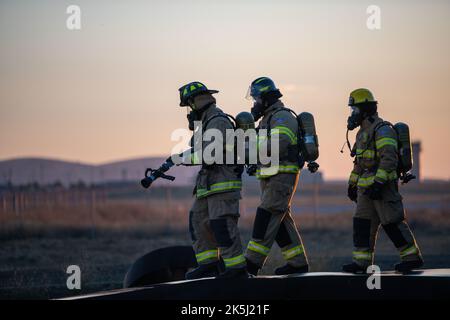 Les pompiers de l'escadron du génie civil 92nd portent un tuyau d'eau lors d'un entraînement en direct à la base aérienne de Fairchild, à Washington, le 19 septembre 2022. Cette formation a fourni une expérience de première main pour des scénarios réels potentiels. (É.-U. Photo de la Force aérienne par Airman 1st classe Jenna A. Bond) Banque D'Images