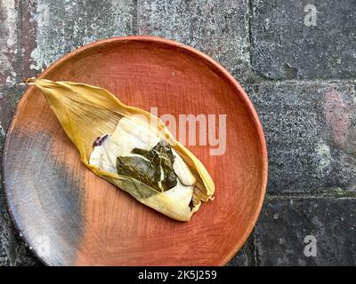 Un Oaxacan Tamal sur une assiette faite avec masa et hierba santa Banque D'Images