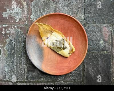 Un Oaxacan Tamal sur une assiette faite avec masa et hierba santa Banque D'Images