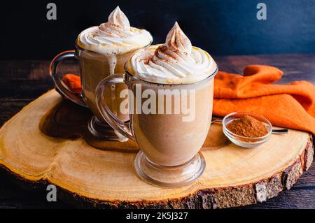 Chocolat chaud aux épices de citrouille recouvert de crème fouettée : mugs de chocolat chaud nappés de crème chantilly et d'épices de citrouille Banque D'Images