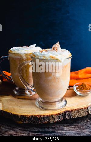 Chocolat chaud aux épices de citrouille recouvert de crème fouettée : mugs de chocolat chaud nappés de crème chantilly et d'épices de citrouille Banque D'Images