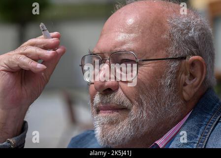 Portrait d'un fumeur avec barbe et prothèse auditive à l'oreille, Bavière, Allemagne Banque D'Images