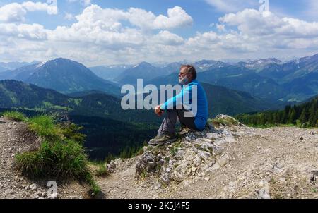 Randonneur, senior, 63 ans, se reposant au sommet de Schildenstein, Kreuth, Mangfall Mountains, haute-Bavière, Allemagne Banque D'Images