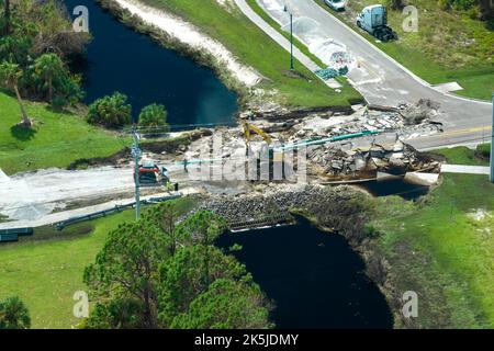 Vue aérienne de la reconstruction d'un pont routier endommagé détruit par la rivière après que l'eau d'inondation a lavé l'asphalte. Reconstruction des transports en ruines inf Banque D'Images