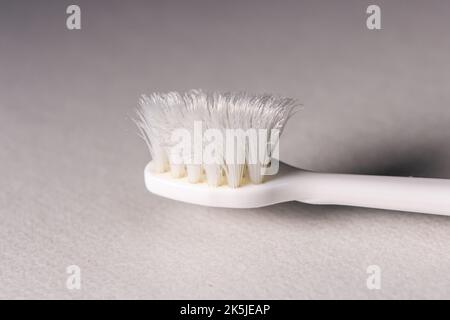 Gros plan sur une vieille brosse à dents sur fond blanc. Les poils de la brosse à dents sont usés. Banque D'Images