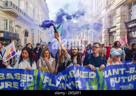 Londres, Royaume-Uni. 08th octobre 2022. Un activiste de la rébellion animale émet une fumée pendant la manifestation. Le groupe des droits des animaux a défilé dans le centre de Londres pour exiger la fin de toutes les formes d'exploitation animale et un avenir fondé sur les plantes. Crédit : SOPA Images Limited/Alamy Live News Banque D'Images