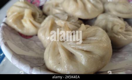 boulettes tibétain momo servies à la vapeur sur une assiette avec farces de porc, poulet, chou, etc. Une spécialité populaire en hiver. Banque D'Images