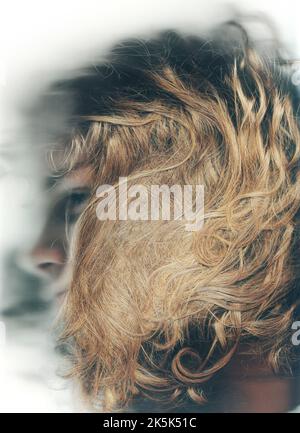 Tout sur moi définit qui je suis. Photo de profil d'un jeune homme avec son visage masqué par ses cheveux longs et bouclés. Banque D'Images