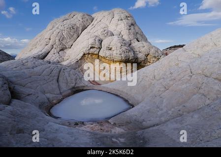 La formation de pierre de sable blanc entoure un petit étang de glace à Wet Pocket, Arizona . Banque D'Images