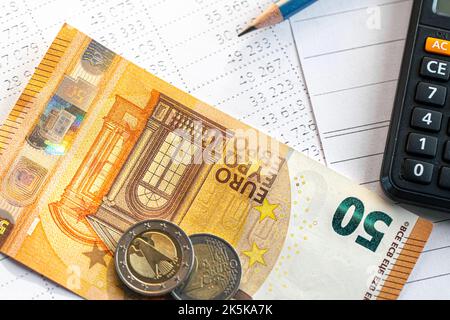 Calculatrice, argent et crayon gros plan sur un arrière-plan flou. Banque D'Images