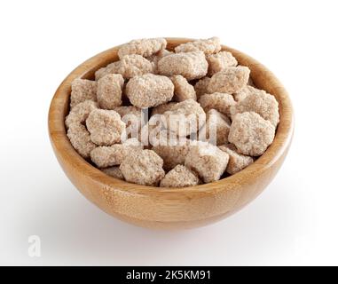 Cubes de sucre de canne dans un bol en bois isolé sur fond blanc avec passe-cheveux Banque D'Images