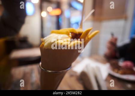 Gros plan des frites hollandaises avec de la mayonnaise dans un cône en papier Banque D'Images