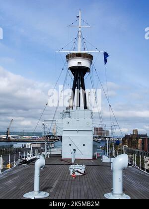 Les corneilles nichent le regard contre un ciel bleu sur un vieux navire de guerre de la Royal Navy. Banque D'Images