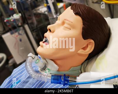 Un mannequin en plastique sur un lit d'hôpital équipé de capteurs de maintien de la vie connectés. Pratique et formation de jeunes médecins dans un simulateur médical. Banque D'Images