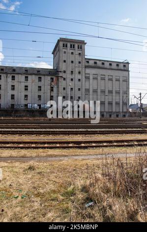 Voies de chemin de fer et train en toile de fond d'un bâtiment industriel abandonné et détruit. Banque D'Images