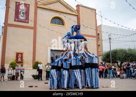 Plaza de la Iglesia, Rojales, Valence, Espagne. 9th octobre 2022. Le 9th octobre de chaque année, les habitants de Valence célèbrent la journée nationale de leur région autonome. Il s'agit d'une commémoration historique de la date de 1238 où le roi Jacques Ier est entré officiellement dans la ville de Valence, la libérant de la domination mauresque. La date est également la célébration de 40 ans de Statut d'autonomie. Des manifestations locales ont lieu, comme sur la place de Rojales, à l'extérieur de l'église Parroquia de San Pedro Apóstol avec les acrobates des pyramides humaines de Muixeranga d'Alicante Banque D'Images