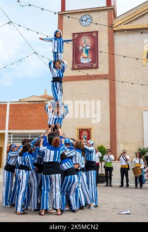 Plaza de la Iglesia, Rojales, Valence, Espagne. 9th octobre 2022. Le 9th octobre de chaque année, les habitants de Valence célèbrent la journée nationale de leur région autonome. Il s'agit d'une commémoration historique de la date de 1238 où le roi Jacques Ier est entré officiellement dans la ville de Valence, la libérant de la domination mauresque. La date est également la célébration de 40 ans de Statut d'autonomie. Des manifestations locales ont lieu, comme sur la place de Rojales, à l'extérieur de l'église Parroquia de San Pedro Apóstol avec les acrobates des pyramides humaines de Muixeranga d'Alicante Banque D'Images