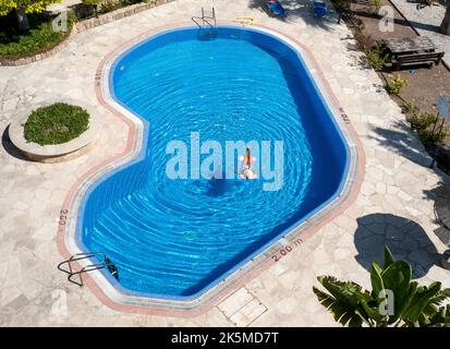 Vue d'en haut d'une dame se relaxant sur un lit d'air dans une piscine, Paphos, Chypre Banque D'Images