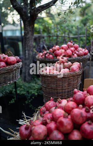 Récolte de grenade mûre sur paille sèche sur le marché agricole extérieur en Turquie. Des aliments sains végétariens Banque D'Images