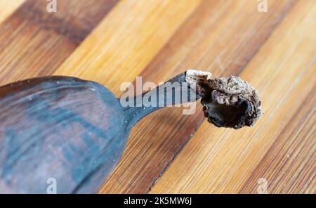 Ancienne banane noire sur un panneau de bambou en bois. Photo macro d'une banane gâtée. Banque D'Images