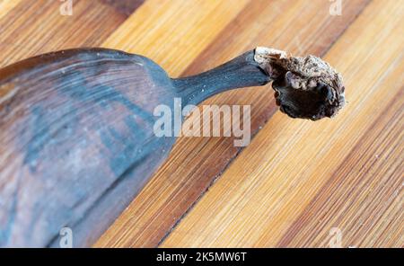 Ancienne banane noire sur un panneau de bambou en bois. Photo macro d'une banane gâtée. Banque D'Images