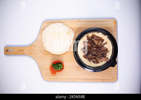 Vue de dessus d'un rôti de manioc Kibbeh nayeh et d'une tomate farcie sur une planche à découper Banque D'Images