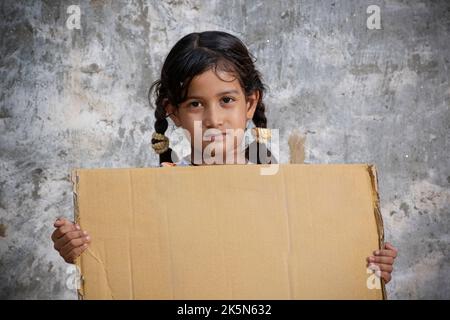 Petite fille tenant une feuille de carton - espace de copie Banque D'Images